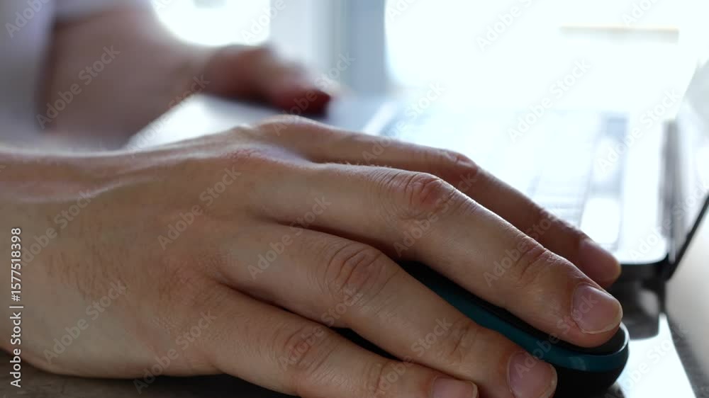 Wall mural computer mouse and programmer working remotely. a man in an office works on a computer and clicks an