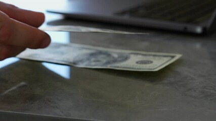 A man puts dollars on a table in a bank.
Financial services in a bank.
A man makes a purchase and pays in cash.
Paper money on a table close-up.
Working in a bank - Powered by Adobe