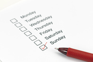 Checklist of weekdays with Sunday marked by red pen, indicating completion or importance. list...