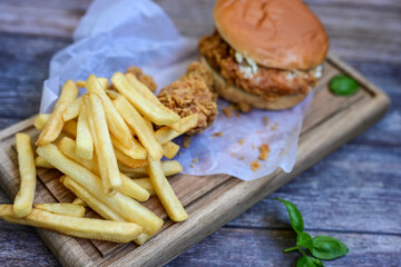   Home made  chicken Burger and   deep fried french fries on wooden   cutingboard 
