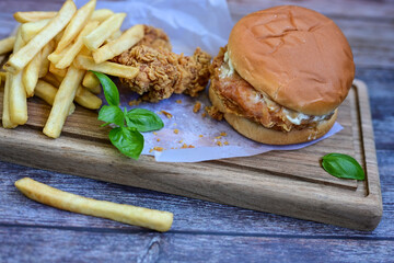   Home made  chicken Burger and   deep fried french fries on wooden   cutingboard 