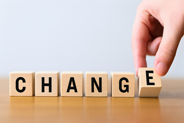 A hand places a wooden block to complete the word change, symbolizing transformation and adaptation.