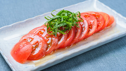 冷やしトマトの薄切りに青じそを添えた夏のさっぱり前菜