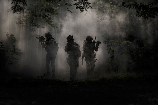 military in the forest . Special Forces Operatives Advancing Through Smoke in Jungle Terrain