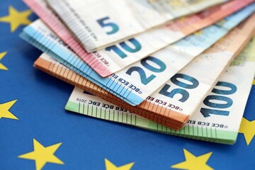 European eur currency money bills on Euro union blue flag close up