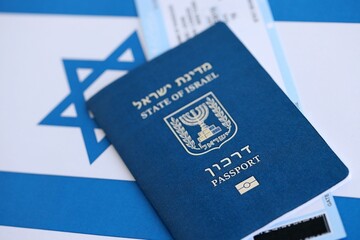 Israel passport and tickets on flag. The current Israel biometrical pass lies on flag close up