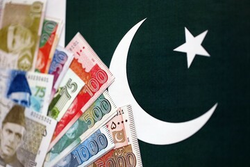Pakistan rupees banknotes on Pakistani flag background. The current Pakistan money bills