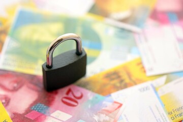 Swiss franc banknotes and padlock. The current francs money bills with lock lies in big amount