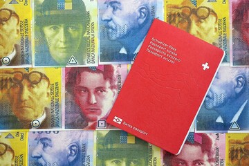 Swiss franc banknotes and passport. The current francs money bills and pass lies on table