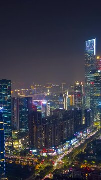 flight over guangzhou city riverside downtown night illumination traffic street aerial timelapse vertical panorama 4k china