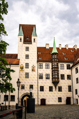 Historic Old Court In Munich With Medieval Architecture And Tower: Beautiful Facade With Red Tiled Roofs, Green Turrets, And Decorative Windows In The Heart Of The Bavarian Capital Near Marienplatz