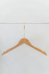 Wooden Clothes Hanger Hanging on a Simple White Background