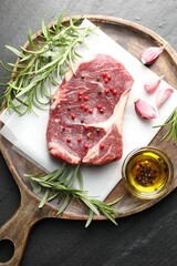 Piece of raw beef meat and spices on black table, top view