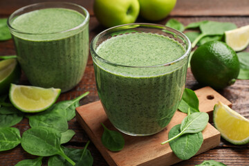 Tasty spinach smoothie and ingredients on wooden table, closeup