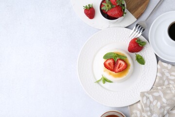 Tasty panna cotta with caramel, strawberries, mint and coffee on light table, flat lay. Space for...