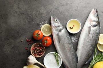 Fresh raw seabass fish with spices on grey table, flat lay and space for text. Seafood delicacies
