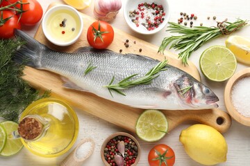 Fresh raw seabass with spices on white wooden table, flat lay. Fish and seafood delicacies
