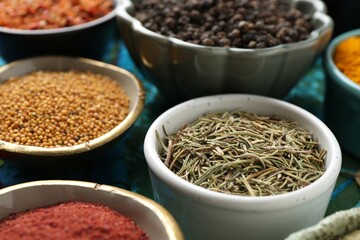 Different aromatic spices on blue tablecloth, closeup