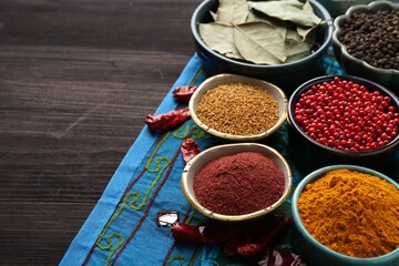 Different aromatic spices on wooden table, closeup. Space for text