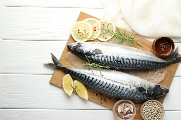 Seafood delicacies. Fresh raw mackerels and spices on white wooden table, flat lay. Space for text