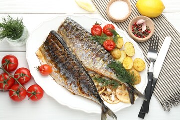 Tasty roasted mackerels with spices, tomatoes and potatoes on white wooden table, flat lay. Homemade seafood dish