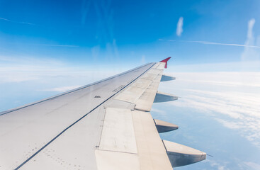 View from the airplane window at a beautiful cloudy sky and the airplane wing