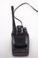 Portable two way radio on charging dock in a minimalist setting for communication needs