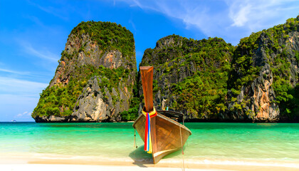 Traditional Longtail Boat on Tropical Beach with Limestone Rock
