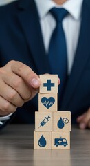 Business professional stacking medical-themed wooden blocks. Healthcare concept with blue medical icons. Clean and organized corporate display.