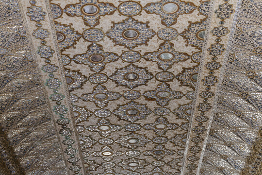 View of the intricate and shimmering ceiling adorned with mirrors and gold patterns, reflecting light in a mesmerizing display, Jaipur, Rajasthan, India.