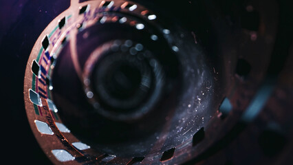 The film creates a vintage and nostalgic feel. Close-up of a roll of film showing the perforated edges and smooth surface.