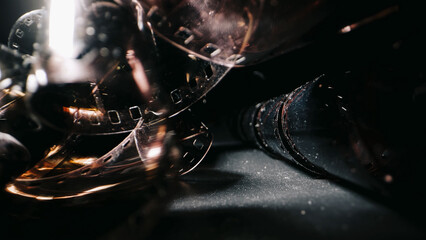 An old twisted color film lies on a dark background, symbolizing memories on the film. The film...