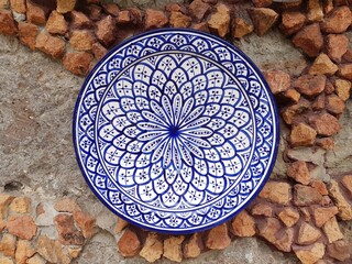 Beautiful hand-painted traditional ceramic plate from Spain on a stone wall