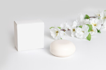 Natural soap with minimalist packaging and floral accents on a light surface showcasing a simple and elegant aesthetic in a well-lit setting