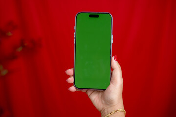Mobile phone, green screen on red background.
