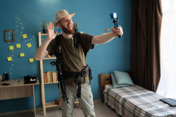 Young bearded man traveler recording video to small camera ready for hiking at home. backpacker...