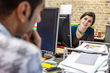 The Media Agency: Working Together. A pair of office colleagues discussing their project in a...
