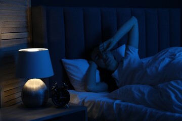 Frustrated woman suffering from insomnia in bed at home