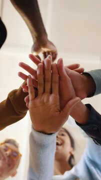 Multiethnic team putting hands together one by one, connection, teambuilding and alliance concept, below view
