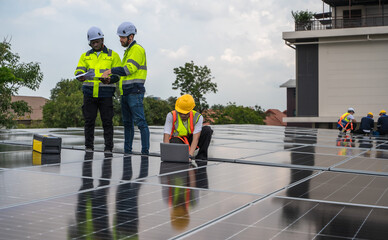 Group of photovoltaic engineer men working together inspecting solar panels on building roof