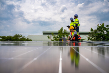 Obraz premium Group of photovoltaic engineer men working together inspecting solar panels on building roof