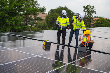 Group of photovoltaic engineer men working together inspecting solar panels on building roof