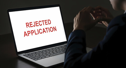 Disappointed Person Viewing "REJECTED APPLICATION" on Laptop: Job Denial, Failure & Frustration.