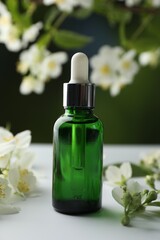 Essential oil and jasmine flowers on white table against blurred background, closeup