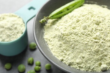 Protein powder and green peas on grey table, closeup