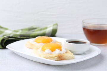 Tasty kaya toasts with half-boiled eggs served on light grey table, closeup. Traditional asian breakfast