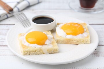 Fototapeta premium Tasty kaya toasts with half-boiled eggs served on white wooden table, closeup. Traditional asian breakfast