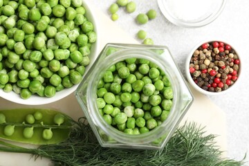 Fresh green peas, pickling jar, spices, salt and dill on white table, flat lay
