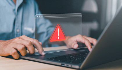 A person is working on a laptop and receives a warning, indicating a computer issue