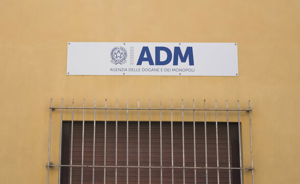 Messina, Italy - June 28, 2025: ADM sign on building facade of Italian customs agency with barred window and yellow wall background